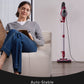 Woman sitting on a couch with a tablet next to a self-standing vacuum cleaner.