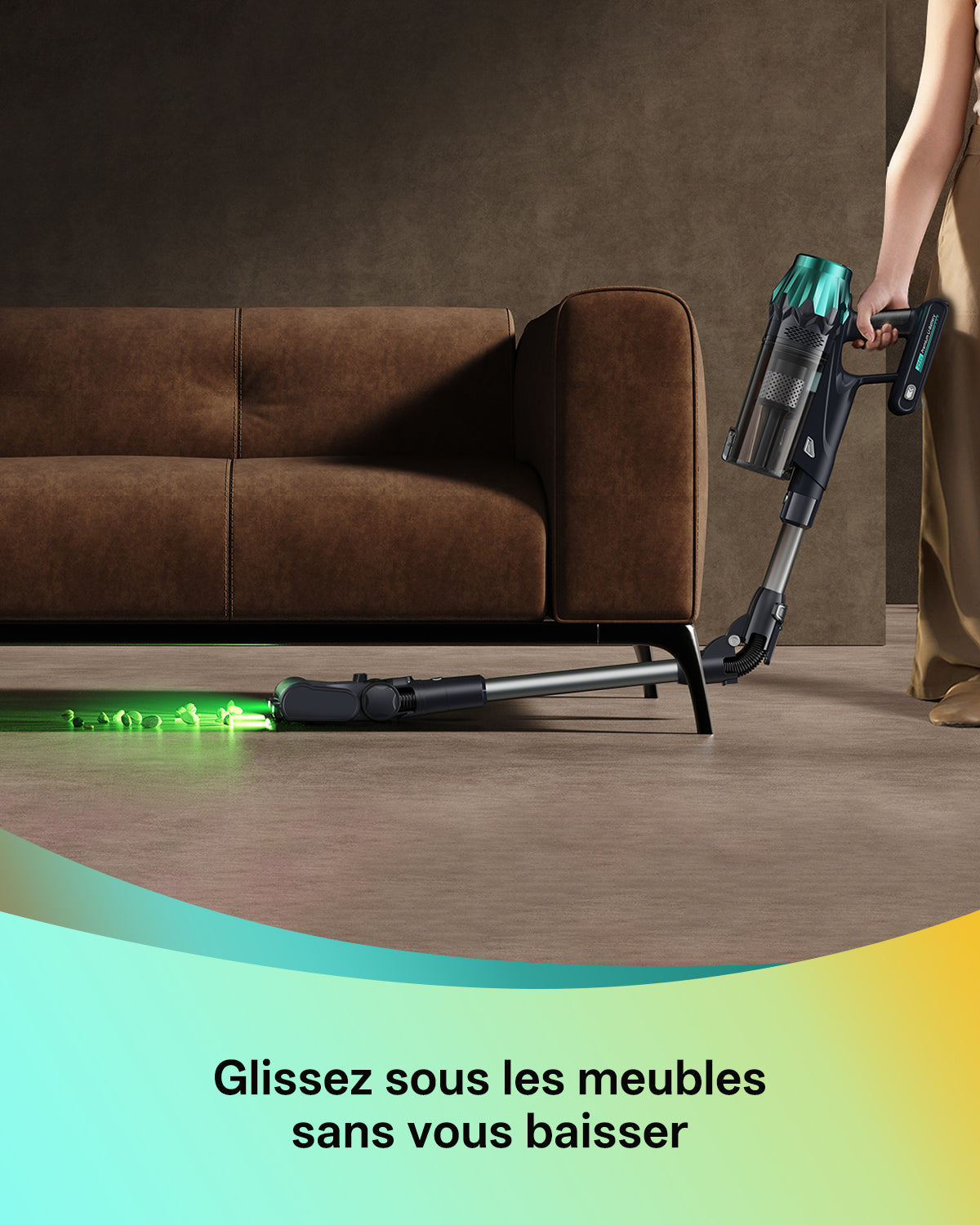 Personne utilisant un aspirateur balai équipé d'un tube et d'une tête de brosse éclairée par une LED verte vive, pour nettoyer sous un canapé en velours brun. Le slogan "Glissez sous les meubles sans vous baisser" apparaît en bas de l'image.